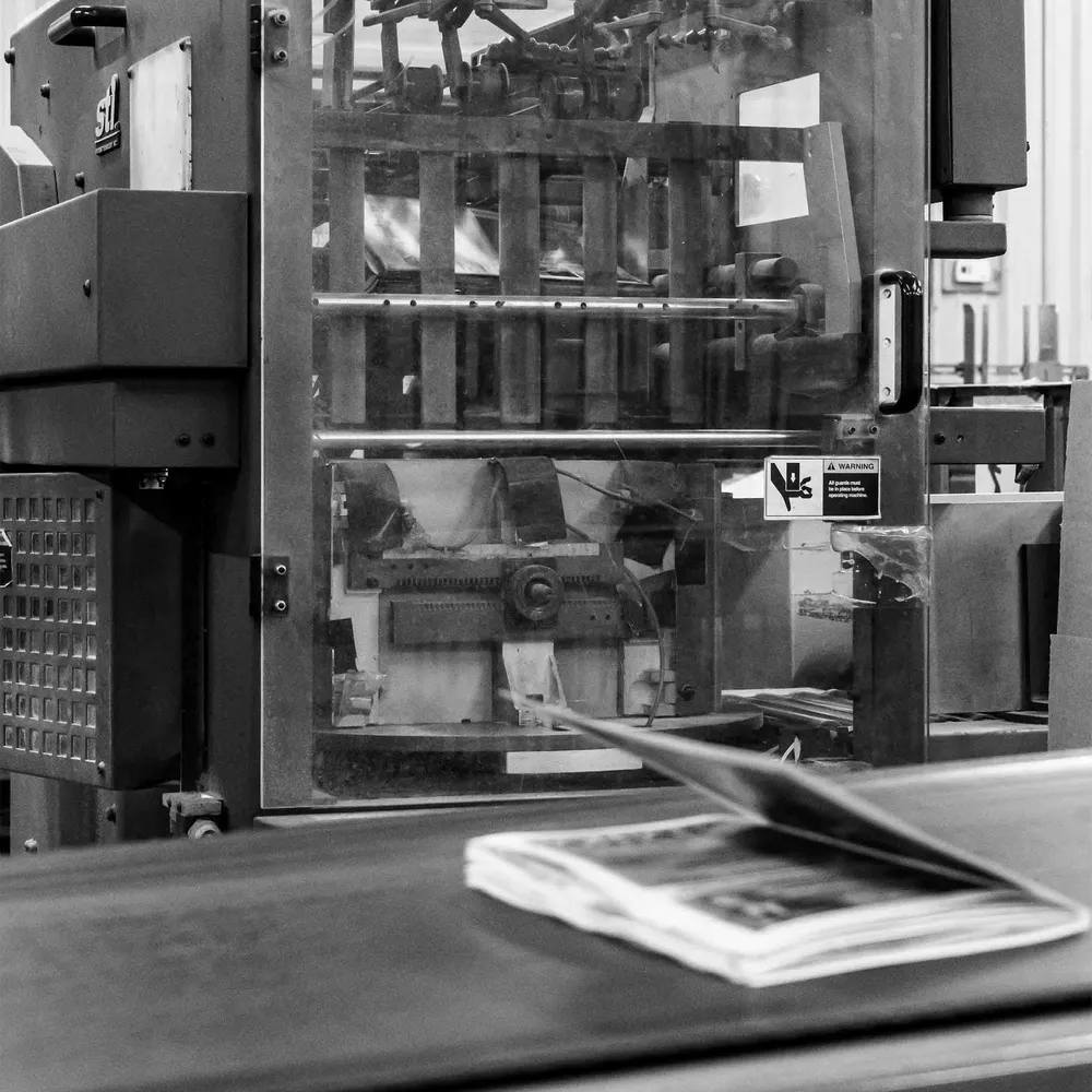 A stitched booklet coming off the saddle-stitcher