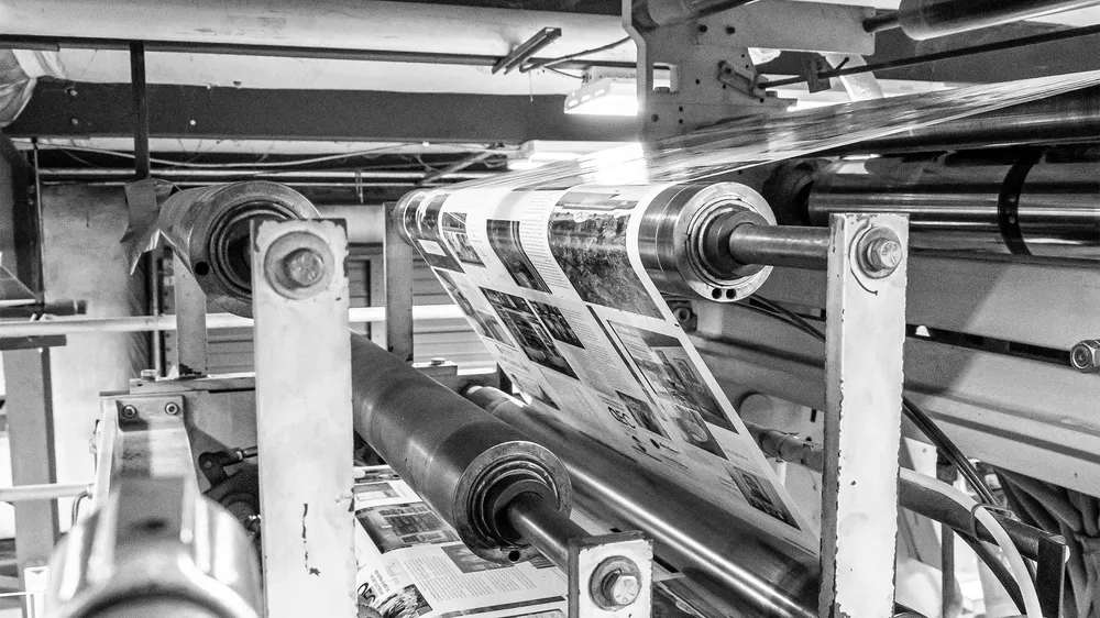 Large printer roller printing pages of magazines