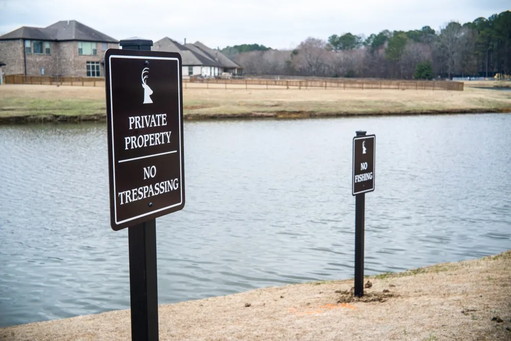 Private Property and No Fishing signs along a subdivision pond