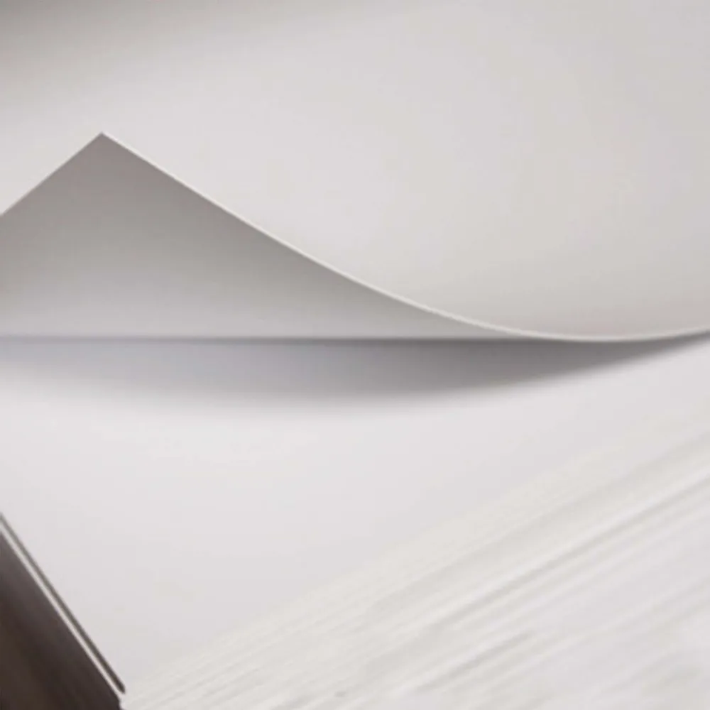 Stack of white styrene sheets with one sheet being lifted up.