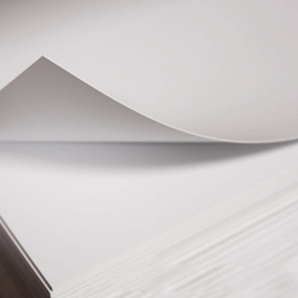 Stack of white styrene sheets with one sheet being lifted up.