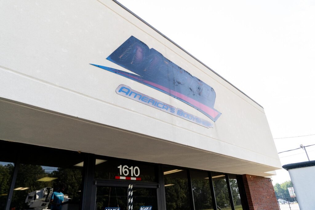 An old sign on the exterior of a building reading "Maaco".