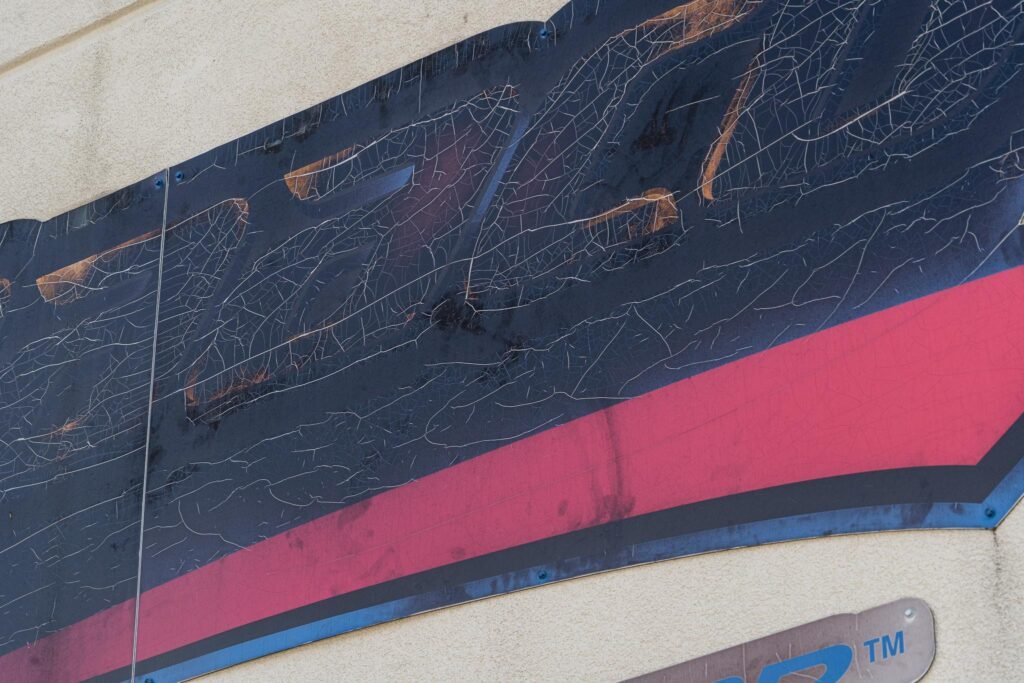 An old, burnt sign on the exterior of a building.