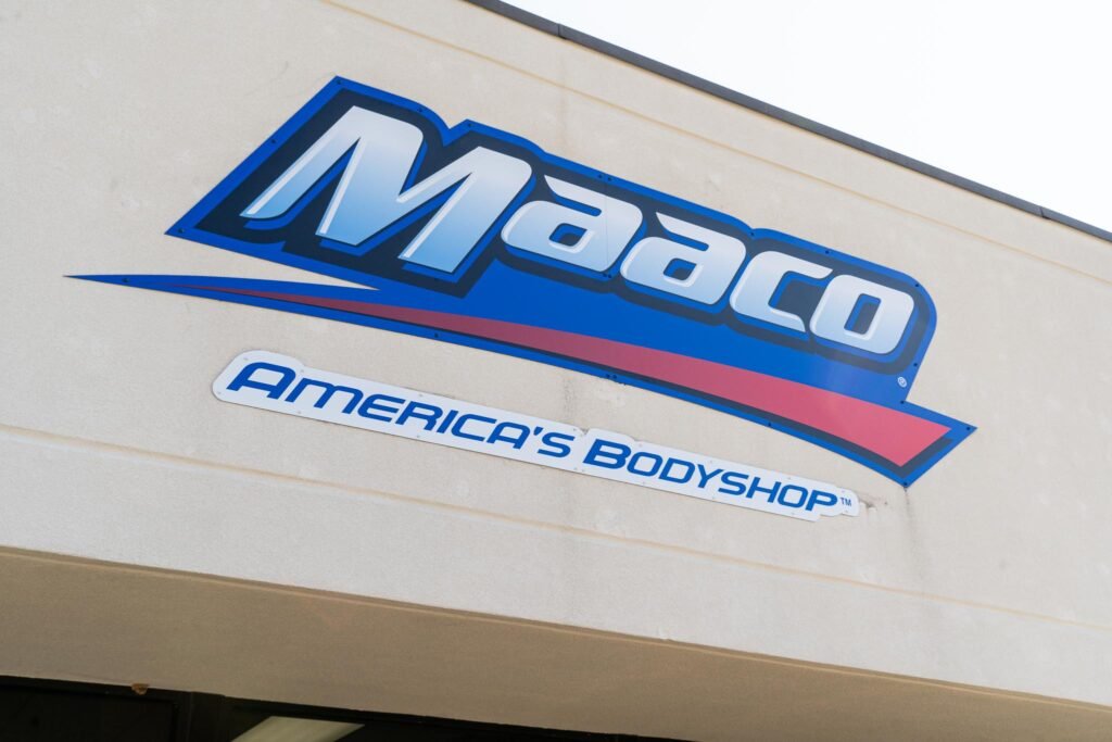 A sign on the exterior of a building reading "Maaco".