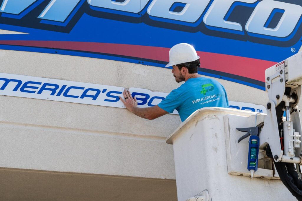 A man in a bucket truck is installing a sign.