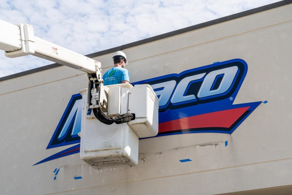 A man in a bucket truck is installing a sign.